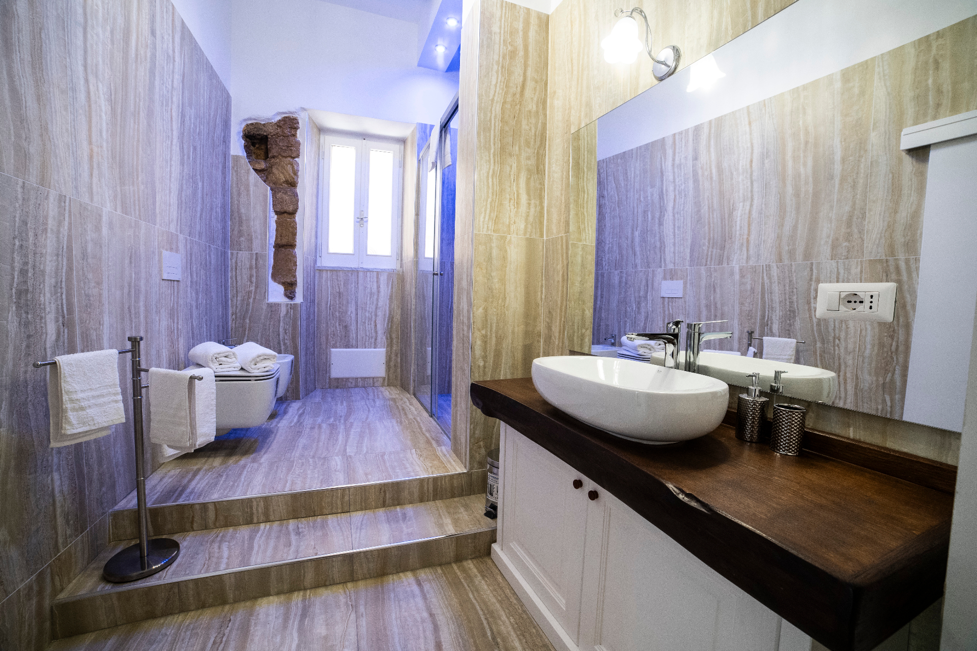 Ampio bagno in travertino con doppio lavabo