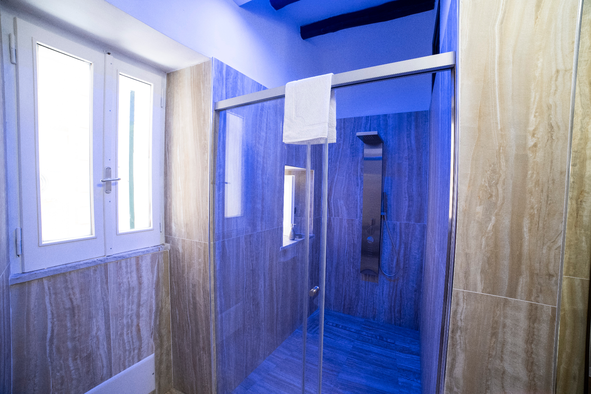 Bagno con doccia moderna e illuminazione cromoterapica